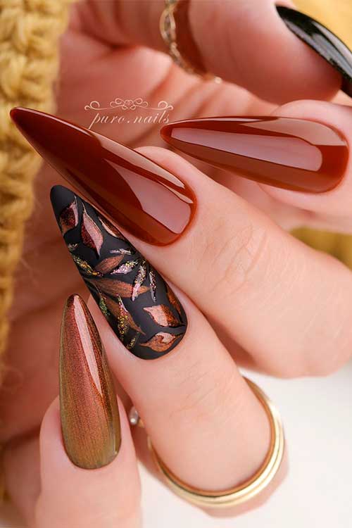 Chestnut and black nails with chestnut leaves on an accent nail are one of the best September nail ideas to try