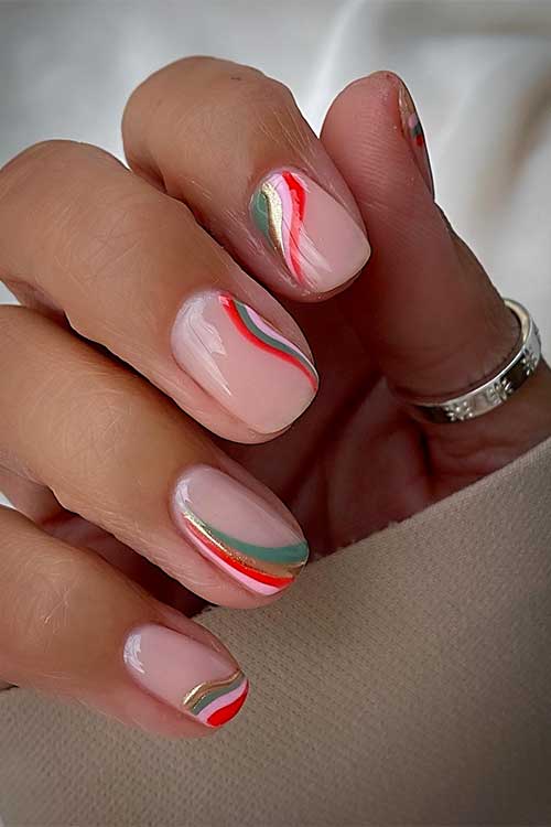 Classy nude nails with green, red, pink, and gold chrome swirls.