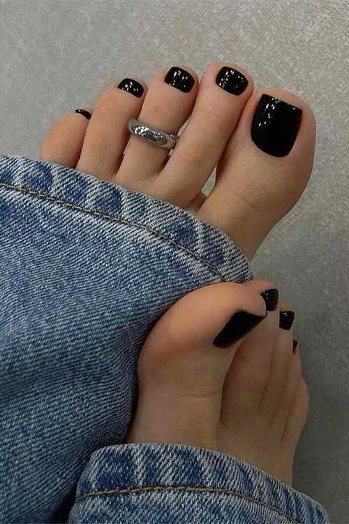 Glossy solid black toe nails for autumn season.