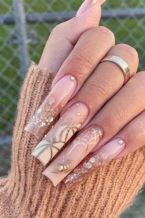 Gold glitter Halloween nails with pumpkins, and spiderweb Halloween nail art designs and adorned with rhinestones. Gold glitter Halloween nails with pumpkins, and spiderweb Halloween nail art designs and adorned with rhinestones.