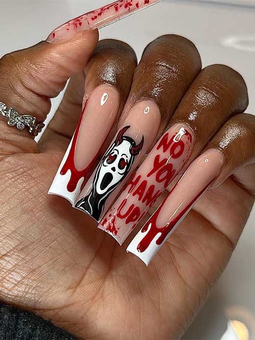 Long Halloween nails with blood splatter, devil with scream face, and blood drip nail art on two accent white French tips