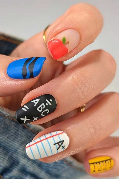 Matte back to school nails features apple, ABC and math Symbols, crayon, notepaper, and ruler accents