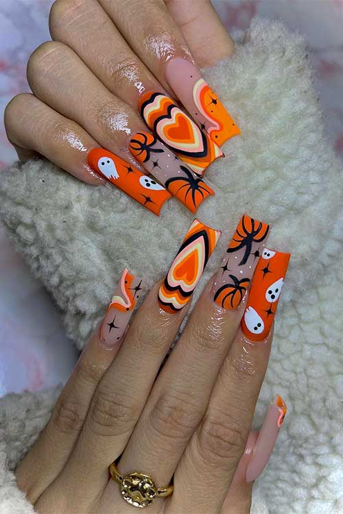 Matte orange Halloween nails with pumpkins, white ghosts, and black stars. Matte orange Halloween nails with pumpkins, white ghosts, and black stars.