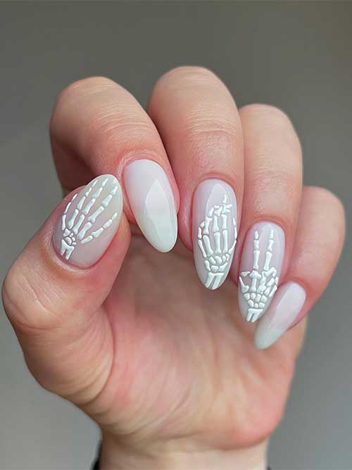 Milk bath white Halloween nails with little skeleton hands.
