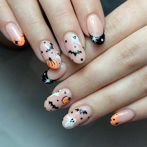Short nude Halloween nails with bats, ghosts, and pumpkins with two accent black and orange French tip nails. Short nude Halloween nails with bats, ghosts, and pumpkins with two accent black and orange French tip nails.