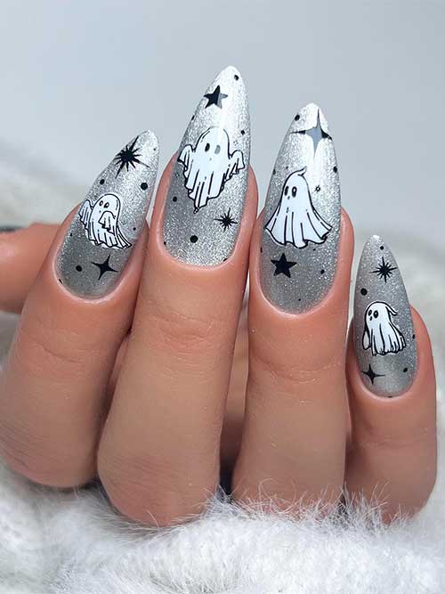 Sparkling silver Halloween nails with white ghosts and black stars. Sparkling silver Halloween nails with white ghosts and black stars.