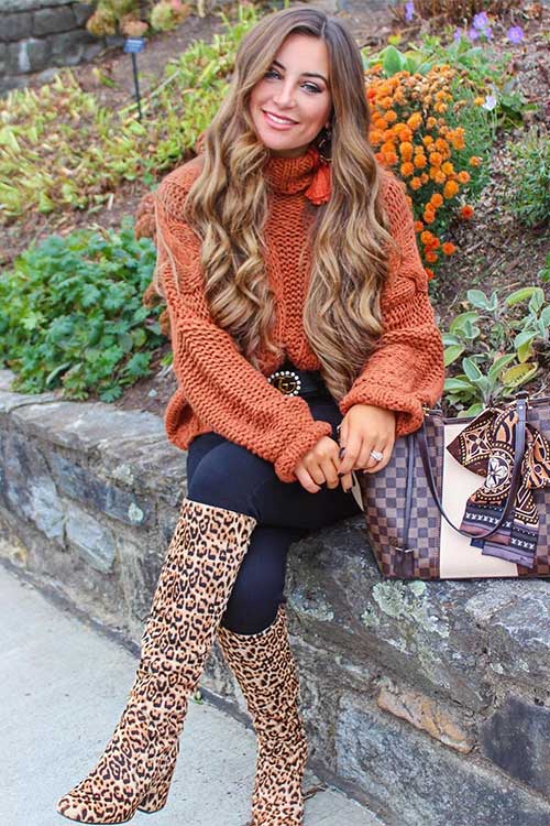 Terracotta sweater and blue pants are incorporated with leopard high boots as fall outfits women for 2023