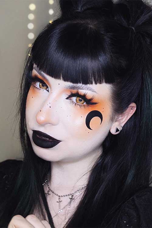 Goth girl Halloween makeup looks scary 2023 with orange eyeshadow, celestial art, black lips, and scary yellow eye contacts Goth girl Halloween makeup looks scary 2023 with orange eyeshadow, celestial art, black lips, and scary yellow eye contacts