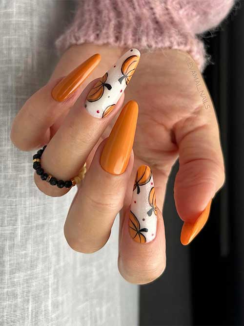 Long almond-shaped burnt yellow nails with burnt yellow pumpkins on two accent shimmer milky white nails