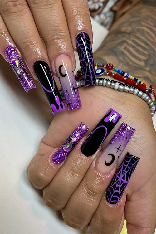 Long black and purple Halloween nails with glitter, rhinestones, celestial nail art, dripping nail art, and cobwebs. Long black and purple Halloween nails with glitter, rhinestones, celestial nail art, dripping nail art, and cobwebs.