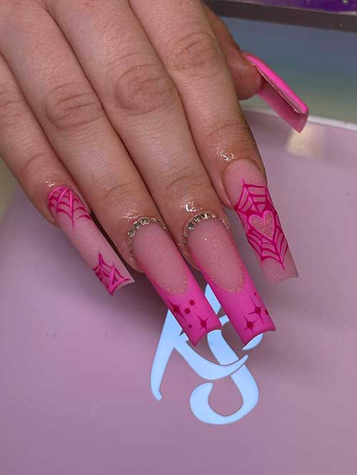 Long pink Halloween nail design over shimmering nude base color, cobwebs, and two accent French tips and rhinestones Long pink Halloween nail design over shimmering nude base color, cobwebs, and two accent French tips and rhinestones