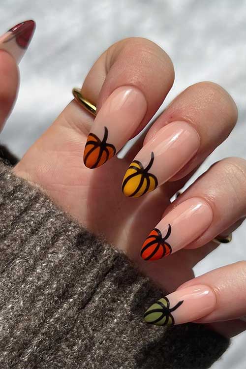 Multicolored French fall pumpkin nails with a pumpkin on each nail tip with different autumnal colors Multicolored French fall pumpkin nails with a pumpkin on each nail tip with different autumnal colors
