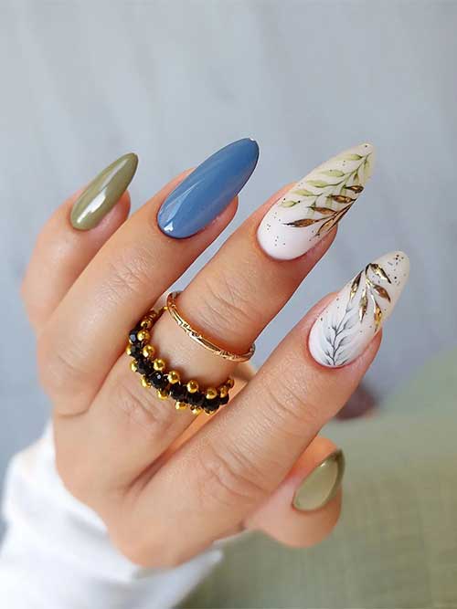 Sage green fall nails with sage green, gold, and black leaf nail art on two accent milky white nails and a blue accent nail