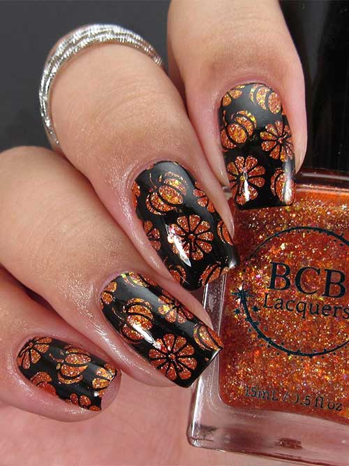 Square-shaped black nails with stamped pumpkins using burnt orange glitter nail lacquer