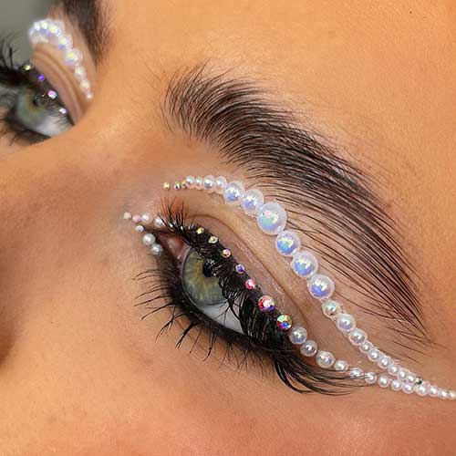 A Natural eye makeup look using sheer glow foundation and black mascara and features a graphic liner look using white pearls