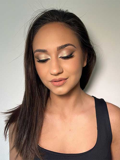 A simple makeup look features nude pearl eyeshadow, black eyeliner, mascara, and nude lips