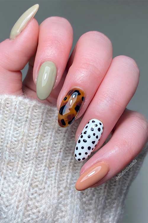 A stunning almond-shaped nail art design features two sage green nails, a tortoise nail, a cow print nail, and a nude nail