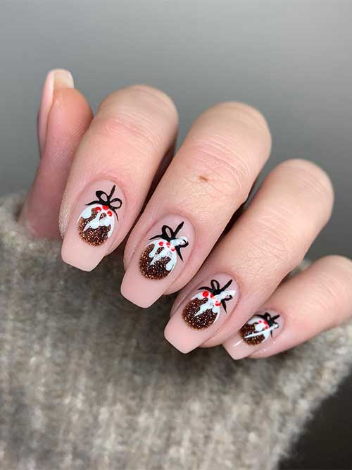 Coffin nude Christmas nails with bronze glitter Christmas ornament on each nail.