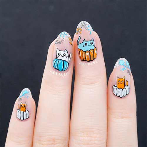 French Thanksgiving Nails 2023 features white, gray, and light blue fall leaves on nail tips and cute kitties on pumpkins