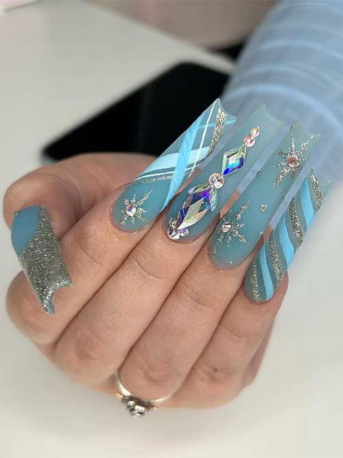 Icy blue Christmas nails with rhinestones, glittery snowflakes, a glittery tip accent, and a sparkling candy cane accent