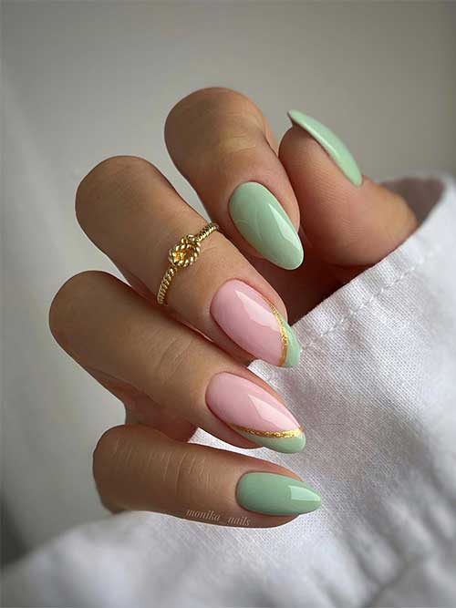 Light sage green almond nails with two accent light pink nails with gold glitter and sage green double diagonal French tips.