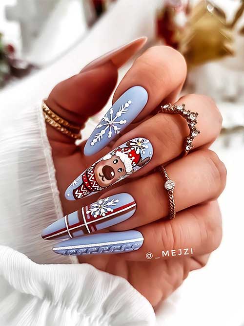 Long almond matte light grey blue Christmas nails with snowflakes, plaid and sweater nail art, and a bear on an accent nail.