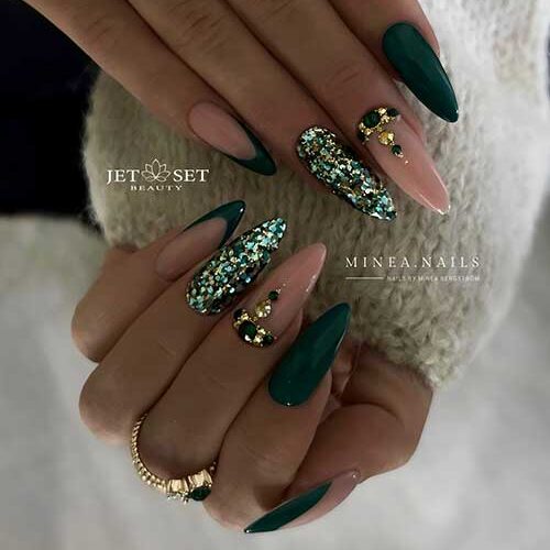 Long almond-shaped dark green nails with gold and dark green rhinestones are the best dark green nail designs for 2023