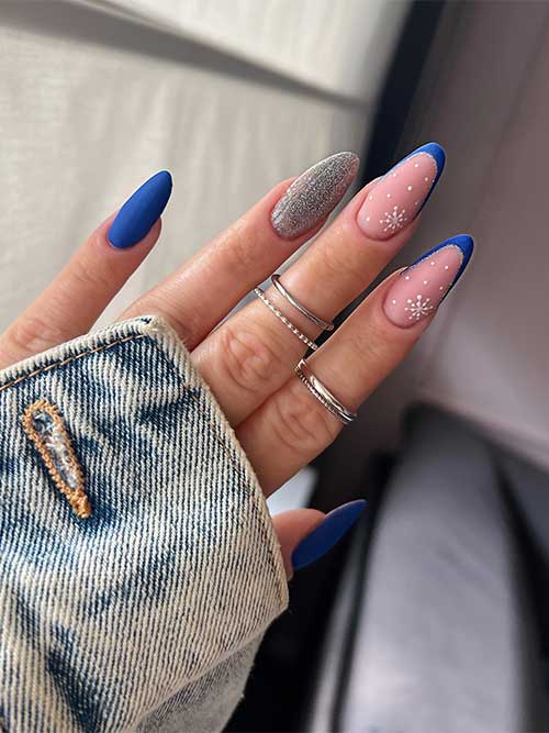 Long almond-shaped matte cobalt blue nails with two accent French tip nails and an accent silver glitter nail