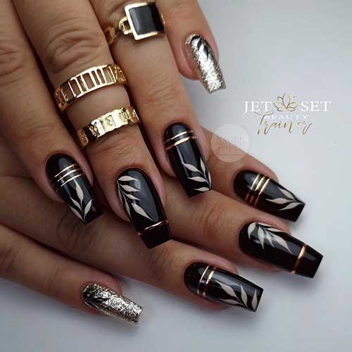 Long coffin black fall nails with beige leaf nail art gold strips and a gold glitter accent nail