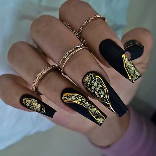 Long coffin matte black fall nails with gold swirls and adorned with gold glitter.