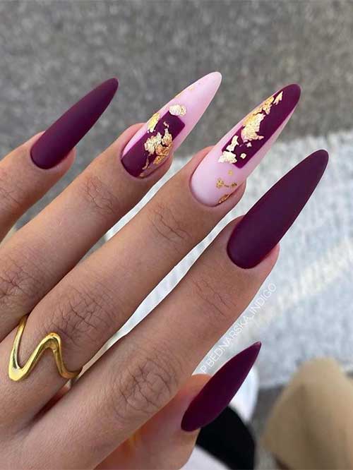 Long matte dark purple nails with two accent light pink nails adorned with gold foil are the best of November nail ideas