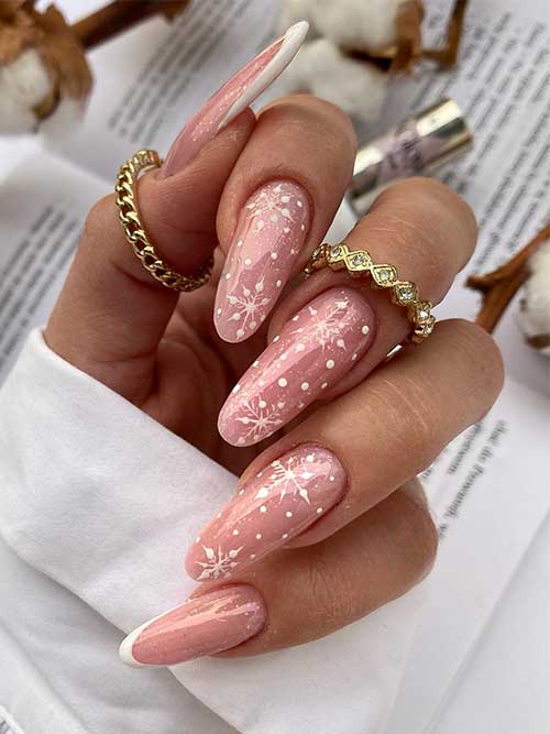 Long nude winter nails almond shaped with a touch of glitter and white snowflakes. Besides, two accent white French tip nails