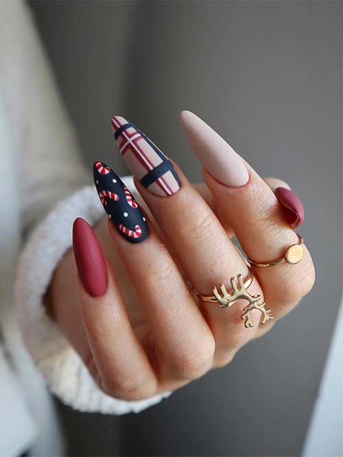 Matte nude and red Christmas nails with red, black, and white plaid nail art, a black accent nail with candy cane sticks.