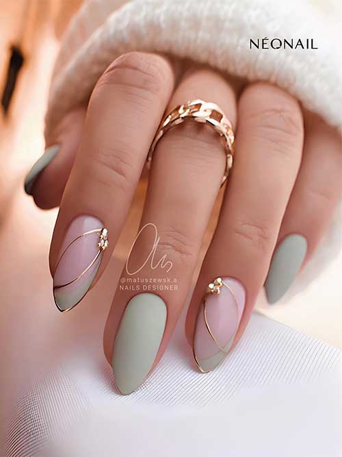 Matte sage green nails with two accent French diagonal nails with gold metallic decorations, outline, and gold rhinestones