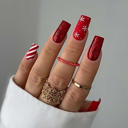 Red Christmas Nails 2023 features two matte red nails with snowflakes and an accent white and red candy cane nail.