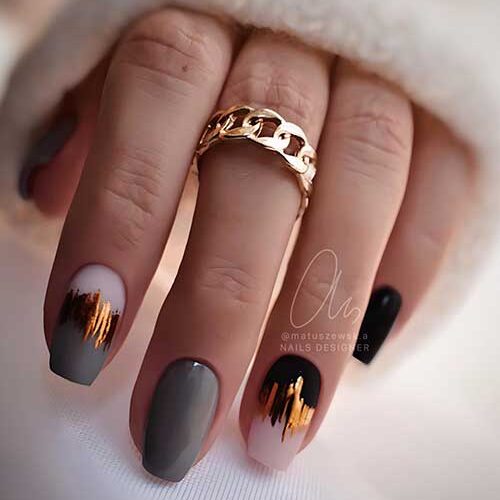 Short coffin gray and black nails adorned with gold foil decorations on two accent nails are the best of grey nail ideas 2023