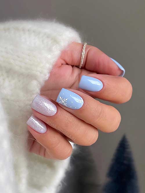 Short ice blue nails one of them adorned with snowflakes and white dots and two accent gel white nails