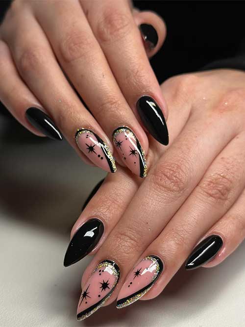 Black New Year’s nails with two accent nude nails adorned with stars and black and gold glitter diagonal French manicure