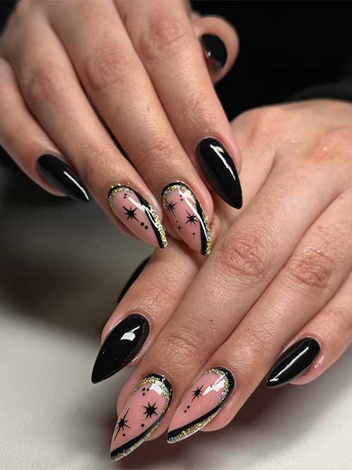 Black New Year’s nails with two accent nude nails adorned with stars and black and gold glitter diagonal French manicure Black New Year’s nails with two accent nude nails adorned with stars and black and gold glitter diagonal French manicure