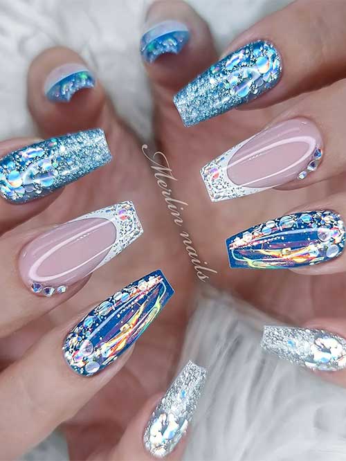 Dazzling blue, white, and silver glitter New Year’s Eve nails with an accent white French tip adorned with three crystals