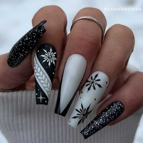 Gel white and black winter nails coffin shaped feature two glossy glitter black nails and snowflake nail art