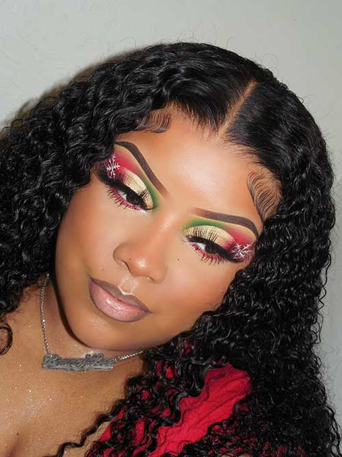 Gold, red, and green eye makeup look with a white snowflake and nude lips that suit curly hair women