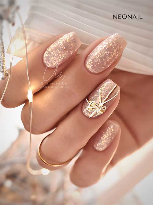 Gorgeous coffin nude Christmas nails with gold aurora flakes and a stamping gift nail art on an accent nail