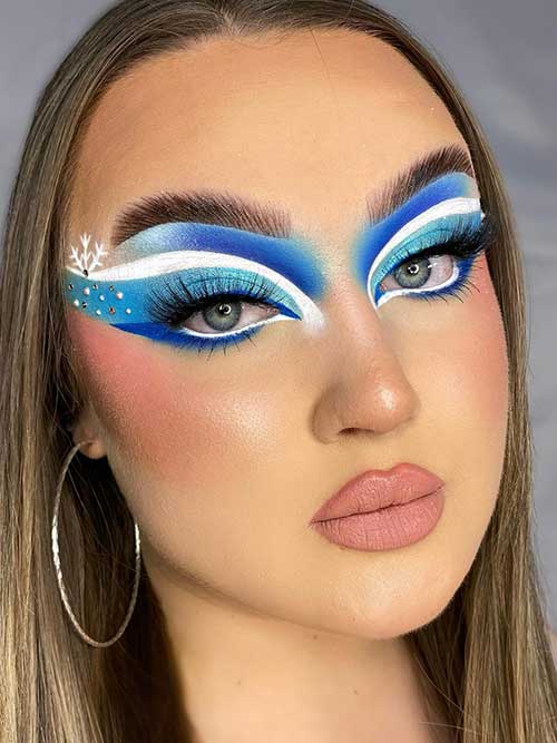 Ice queen eye makeup using light blue, white, and royal blue eyeshadows and one of the cutest Christmas makeup 2023 looks