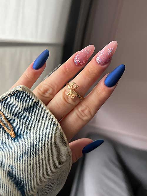 Long almond simple matte navy blue winter nails with two accent nude pink nails adorned with snowflakes and glitter