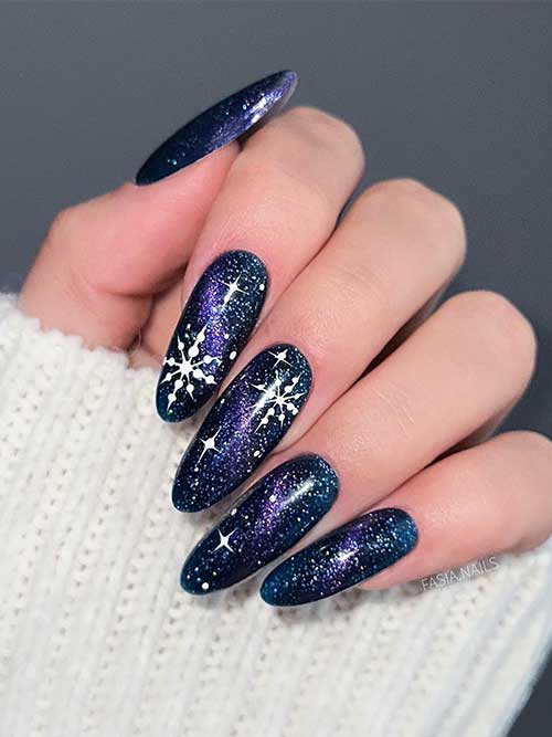 Long black nails with glitter resembling a galaxy. Besides, a touch of purple, and white stars, and big snowflakes