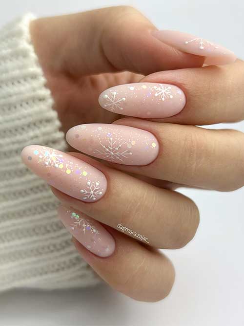 Long matte nude nails with a touch of glitter and white snowflakes for Christmas celebration.