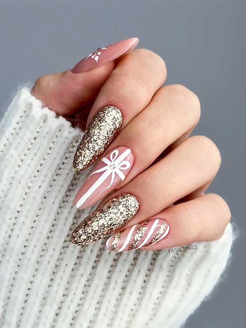 Long nude Christmas nails feature snowflake nail art, tie nail art, candy cane nail art, and two accent gold glitter nails