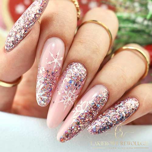 Long rose gold glitter Christmas nails with a little holographic glitter and three nude accents adorned with white snowflakes