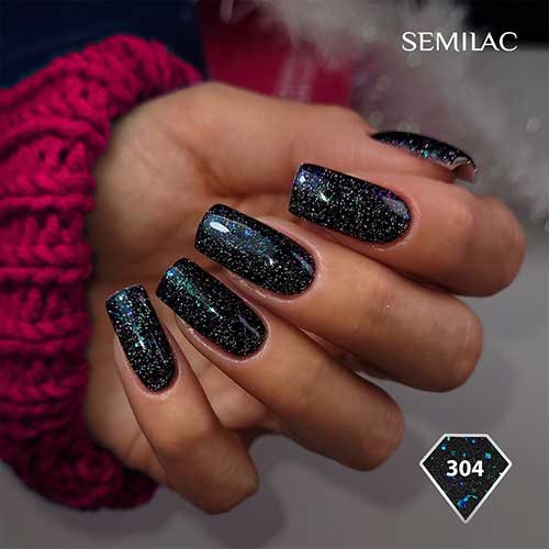 Long square-shaped sparkling black New Year’s nails with silver glitter and a touch of colorful glitter.